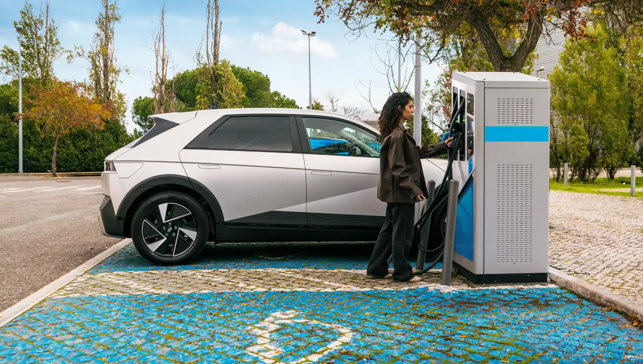 pessoa num posto de carregamento elétrico